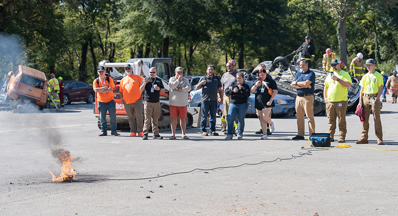 A CIS employee conducts a lithium battery safety demonstration outdoors.