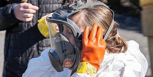 A woman wears a full hazmat suit during a hazmat training.