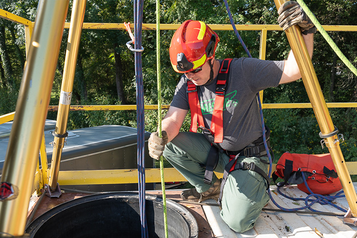 A first responder trains with a confined space simulator.